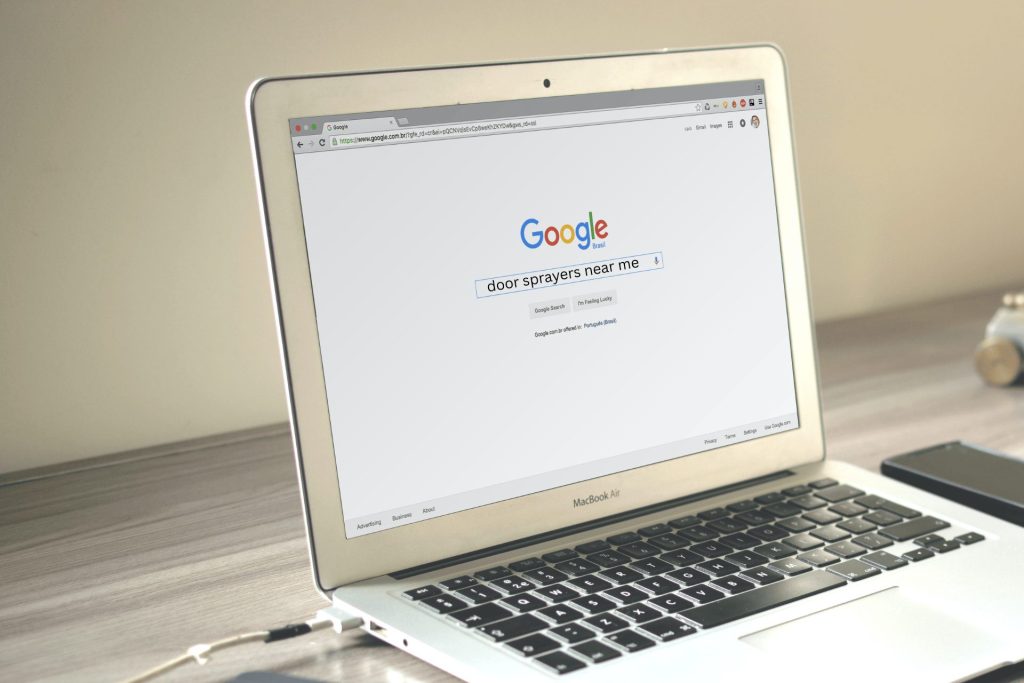 Someone searching for door sprayers near me on Google on a MacBook Air